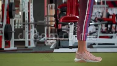 穿着运动服的漂亮运动健身女孩正在健身房做<strong>向前冲</strong>的运动